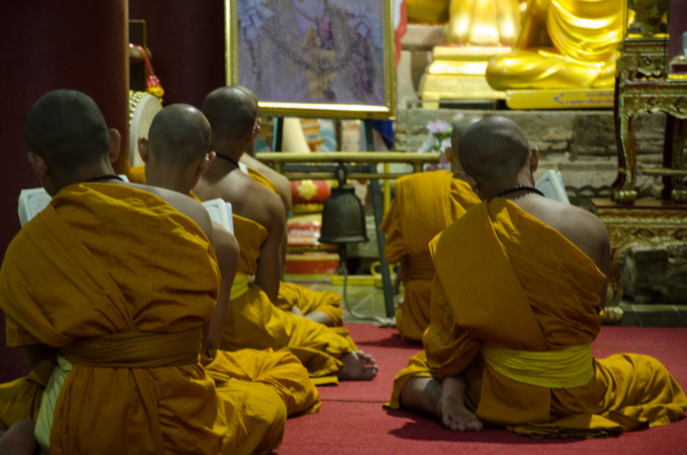 Buddhist Monks chanting in a temple in Chiang Mai, Thailand.